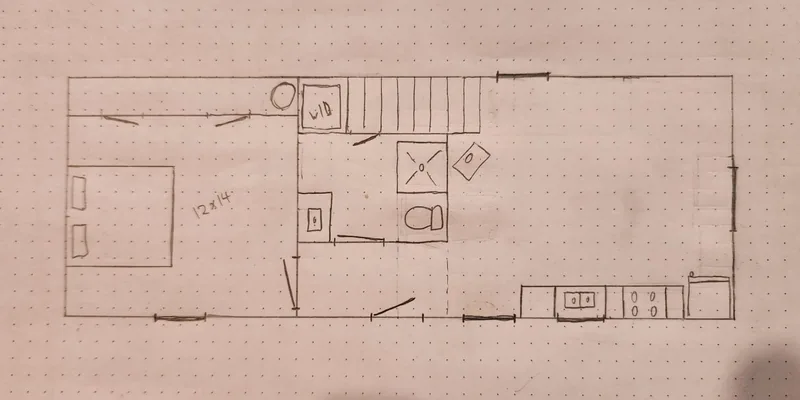 Sample hand-drawn floor plan of the 12×40 lofted cabin: bedroom at one end, washer/dryer and stair to the loft, bathroom with shower and toilet, and open living area