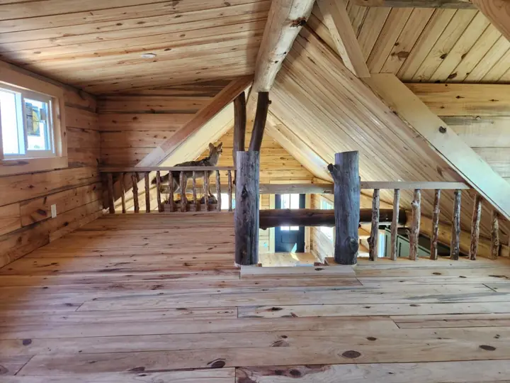 Loft with log railing above the living area