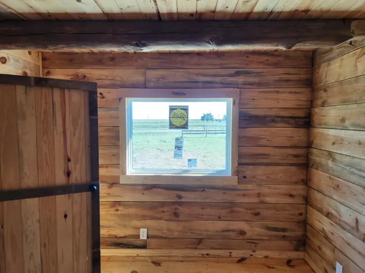 Laundry area with window in a solid-log cabin