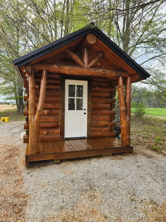 Solid-log cabin front with gable trim and porch