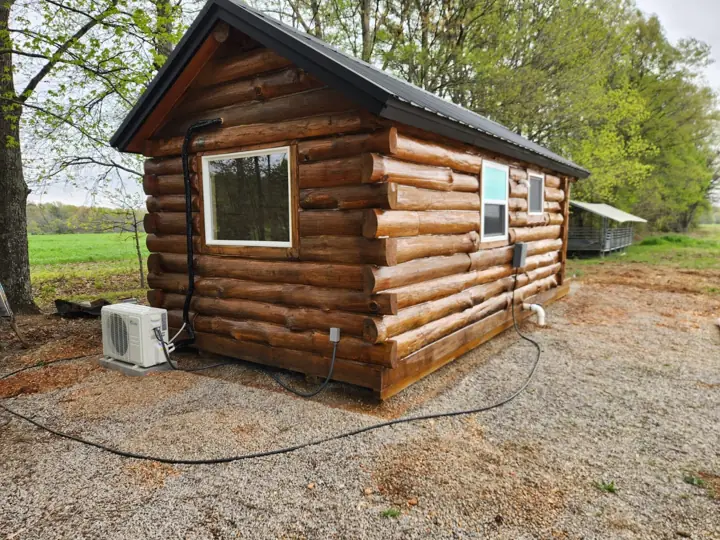Solid-log cabin side with mini-split outdoor unit