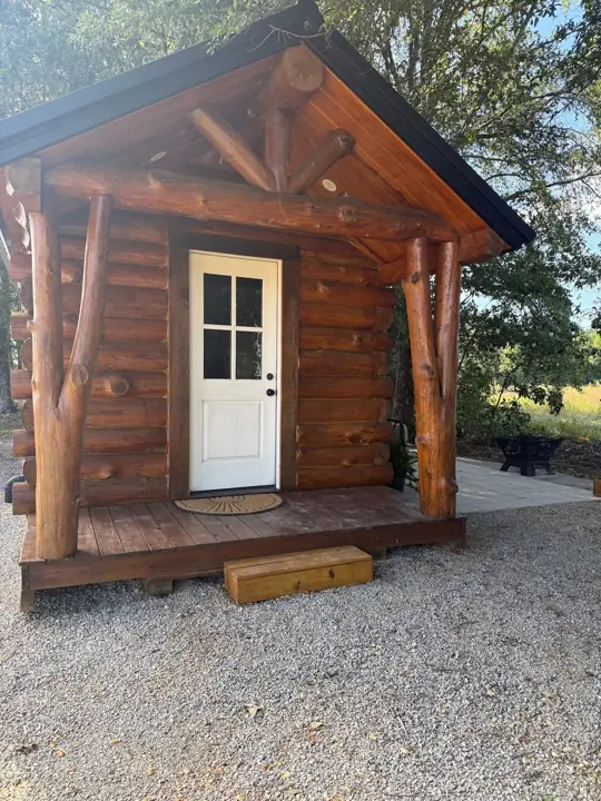 Solid-log tiny cabin with porch — Cozy Cabin Airbnb stay, Clay County, Mississippi